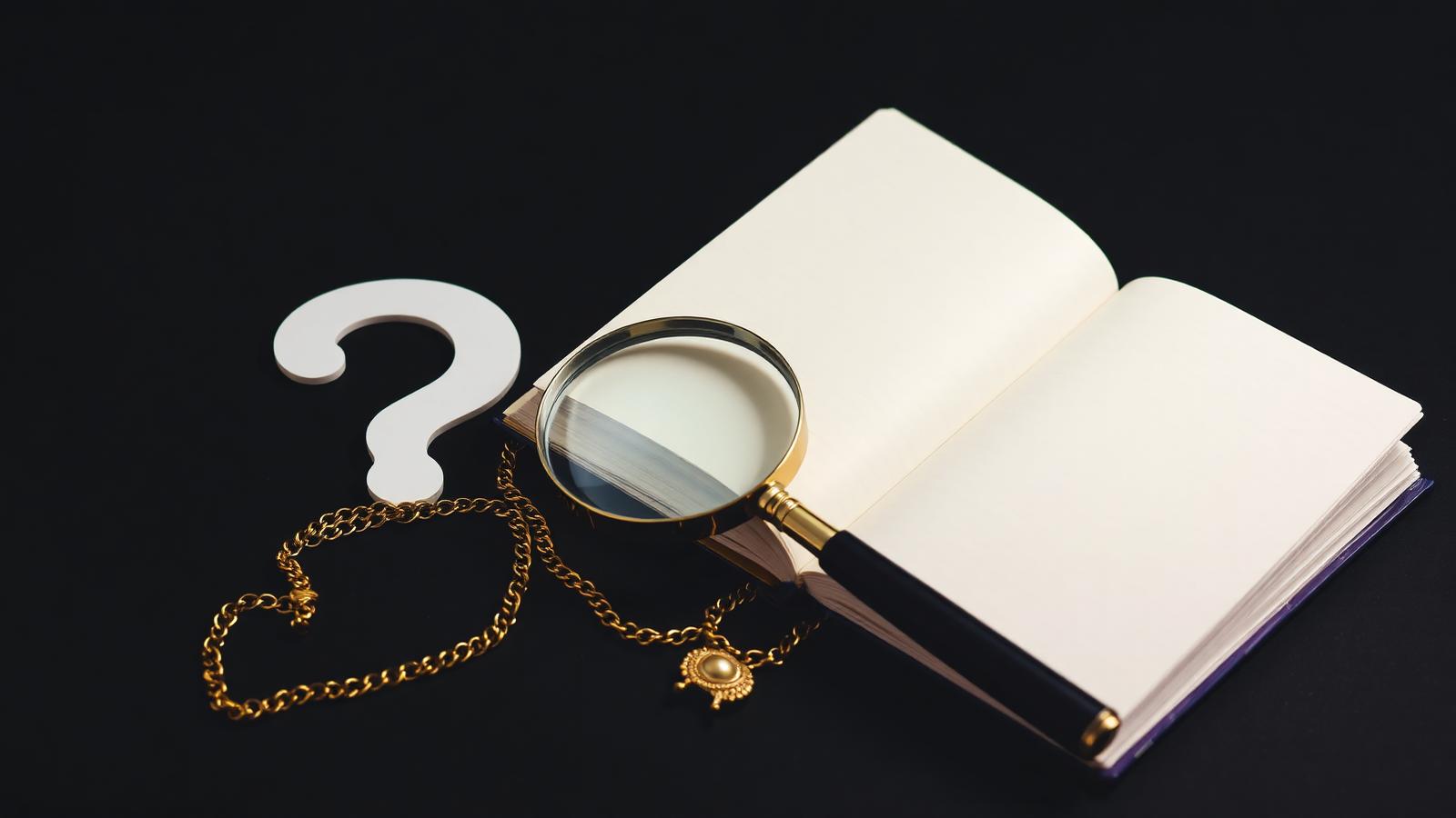 Open notebook with magnifying glass over gold jewelry